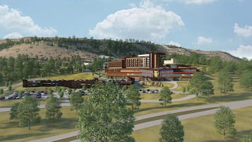 Situated on a grassy hill, this hotel offers a serene view of the surrounding trees.