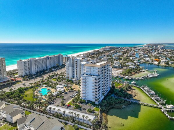 A coastal resort area with a large hotel, a marina, and a beach.
