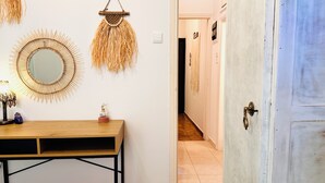 Un couloir avec une table en bois, un miroir et des éléments de décoration murale.