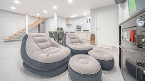 Een modern interieur met een trap, zithoek en een kitchenette.