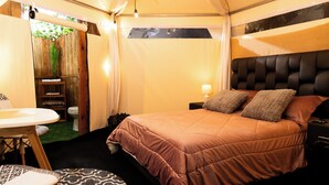 A compact bedroom with a single bed, a small table, and a chair. - Look & Luck Glamping by David (Calacali)