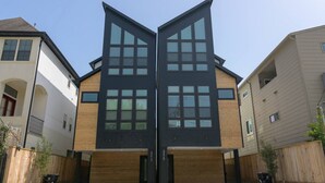 Un bâtiment moderne à la façade symétrique, doté de grandes fenêtres et d’une entrée de garage.