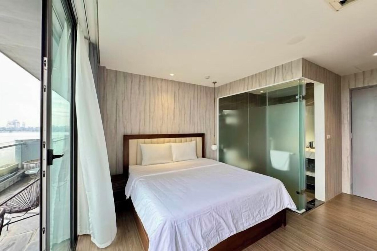 Une chambre moderne avec un grand lit, une douche en verre et une vue sur la ville.