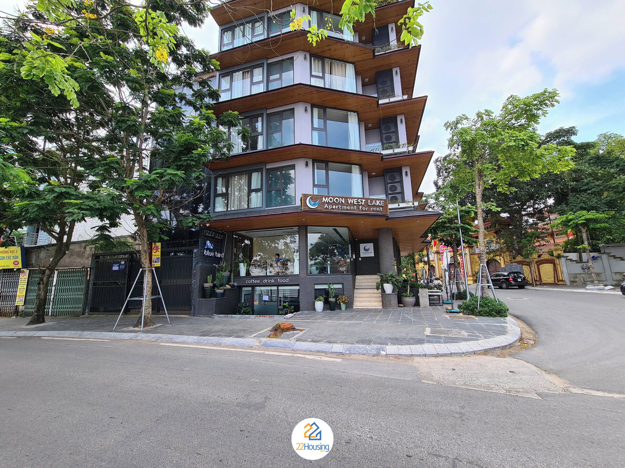 A multi-story building with a sign for 'Moon West Lake Apartment for rent'.
