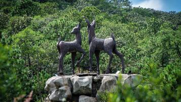 A sculpture of deer on a rocky outcrop surrounded by dense forest.