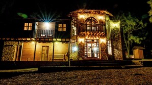 A two-story stone building with a balcony and a wooden door. - Roca Venados (Mascota)