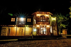 A two-story stone building with a balcony and a wooden door. - Roca Venados (Mascota)