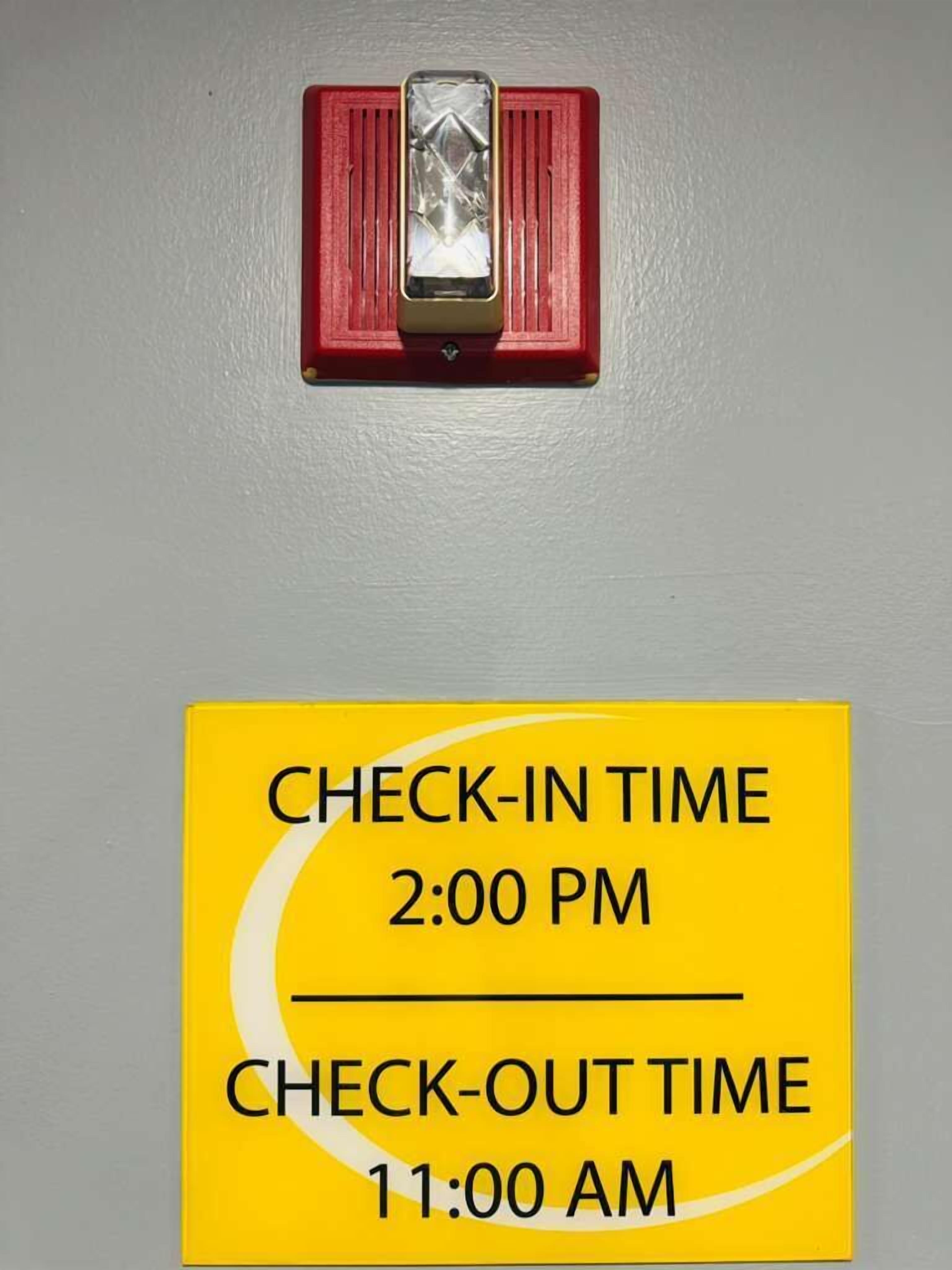 Un letrero amarillo con los horarios de registro de entrada y salida.