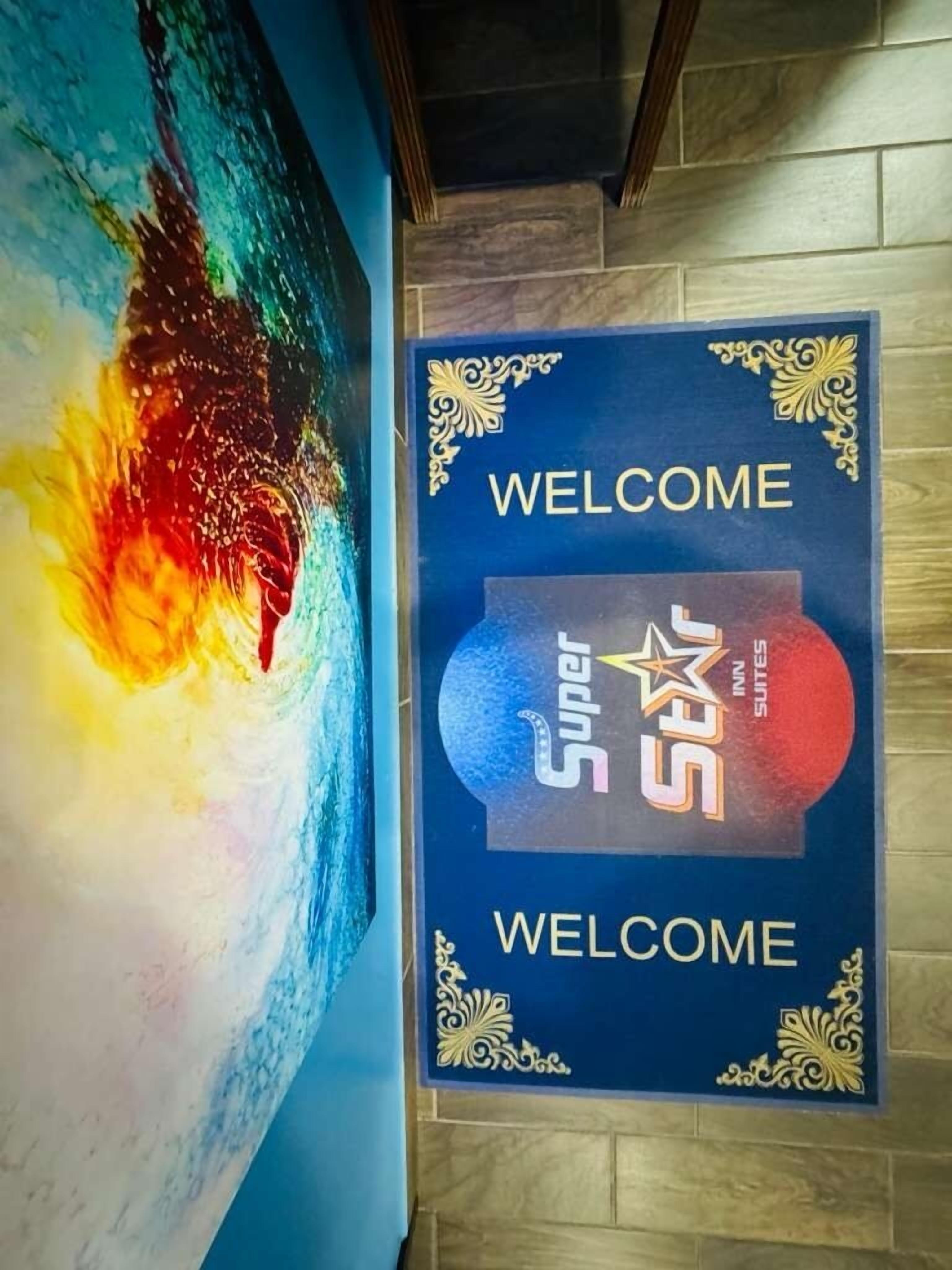A wall with a 'Welcome' sign and a Super Star Inn Suites logo.