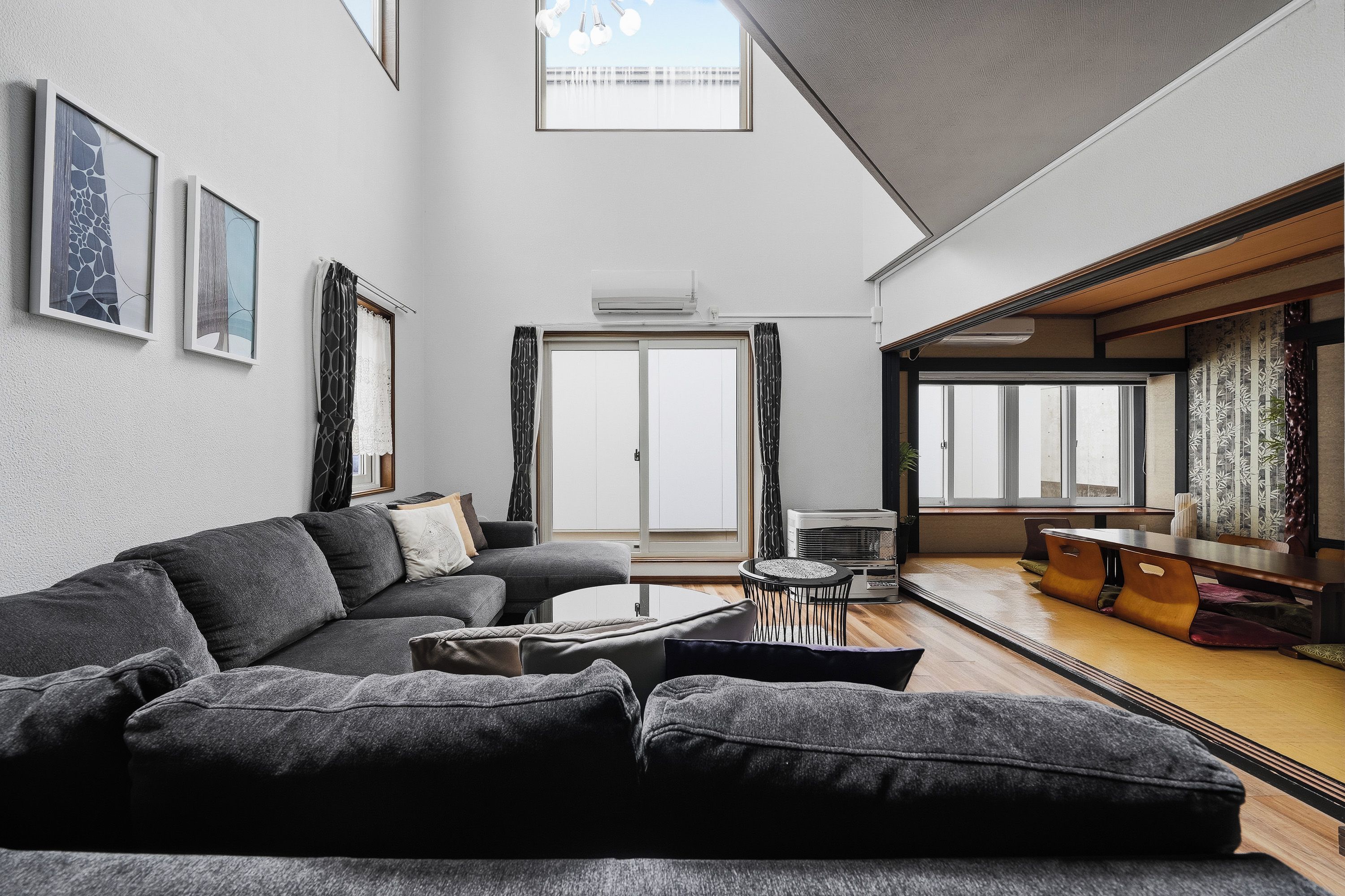 A spacious living room with a sofa, a coffee table, and a dining area with a table and chairs.