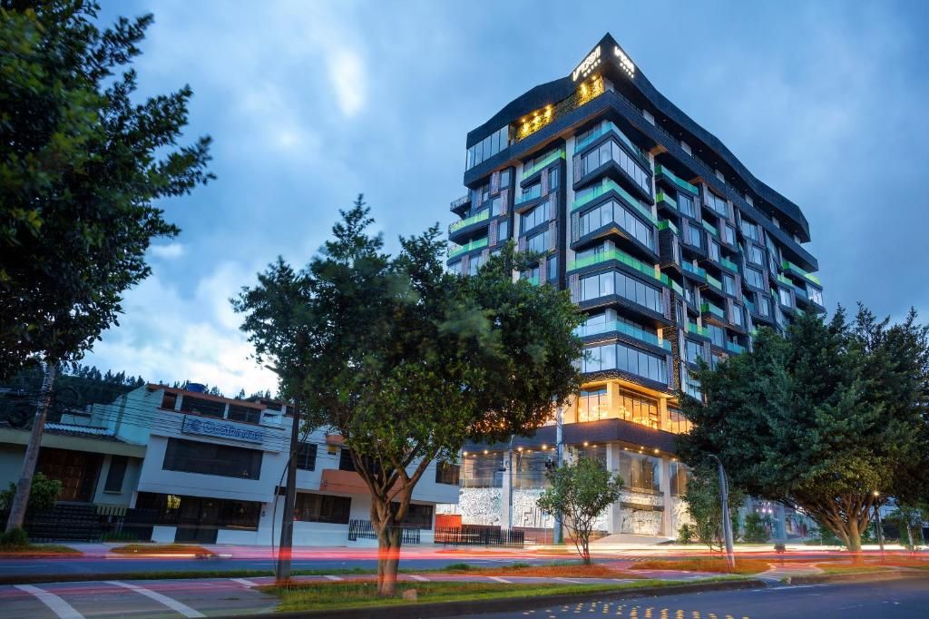 Un hotel de varios pisos con un diseño moderno, que cuenta con balcones y ventanas amplias.