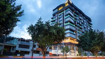A multi-story hotel with a modern design, featuring balconies and large windows.