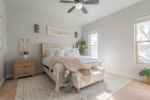 A bedroom with a bed, nightstand, dresser, and a ceiling fan. - 4BR Modern Farmhouse , Sleeps 10 , Backyard & Theater Room (Yuma)