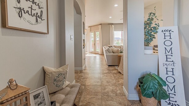 A spacious hallway with a neutral color palette, a comfortable seating area with cushions, and a decorative sign that reads "HOME sweet HOME". - 4BR Modern Farmhouse , Sleeps 10 , Backyard & Theater Room (Yuma)