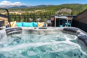A hot tub with a mountain view, a table with chairs, and a railing. - Steps to Downtown Near Trails (Winter Park)