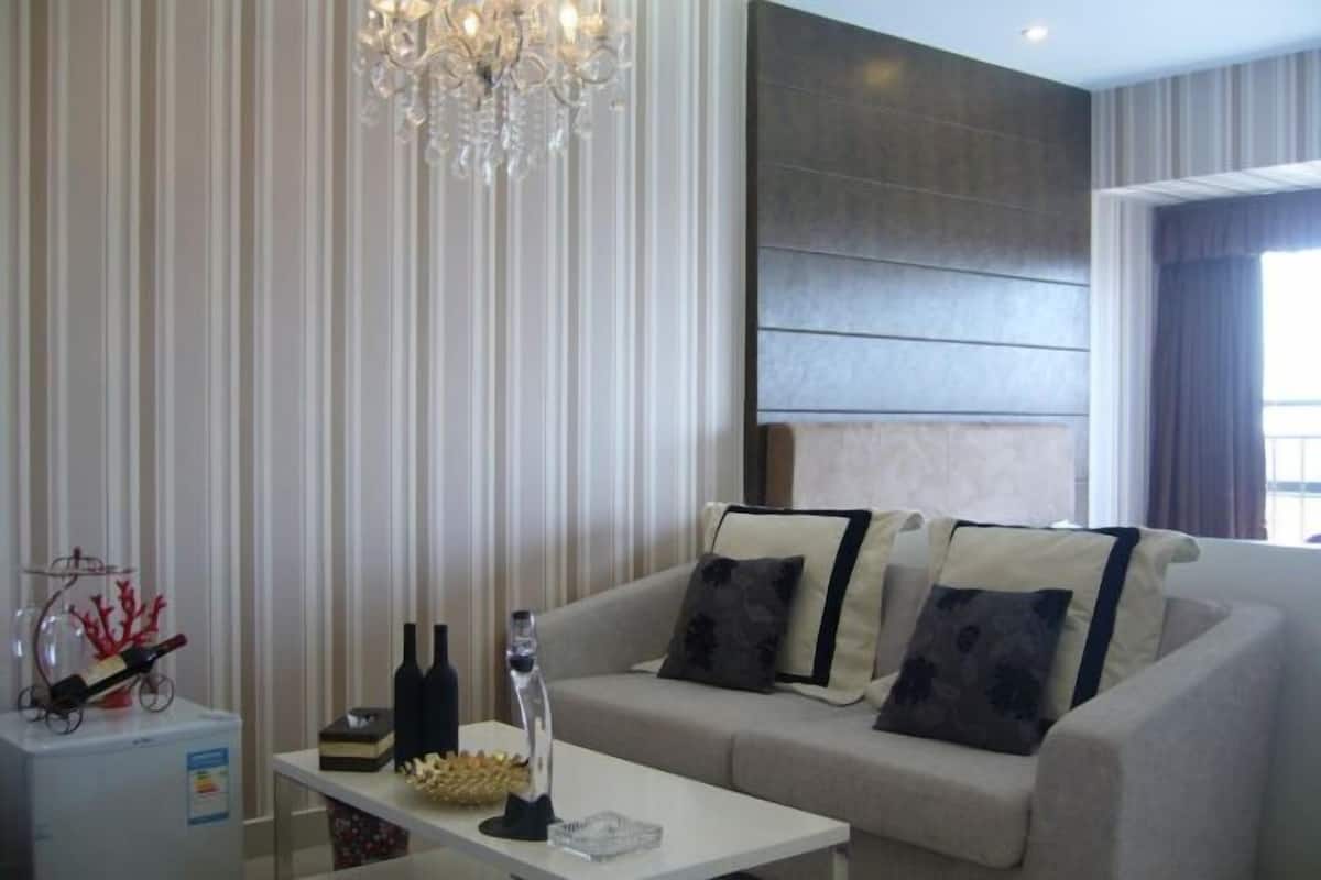 A modern living room with a sofa, a coffee table, and a decorative chandelier.