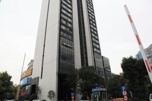 A tall building with multiple floors, a parking sign, and a pedestrian crossing. - Han Palace Ginza Apartment (Wuhan)