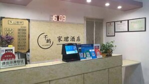 A hotel reception desk with a digital clock displaying 16:03, a cash register, and a sign requesting ID card presentation. - Tianjin Jiajun Express Hotel (Tianjin)