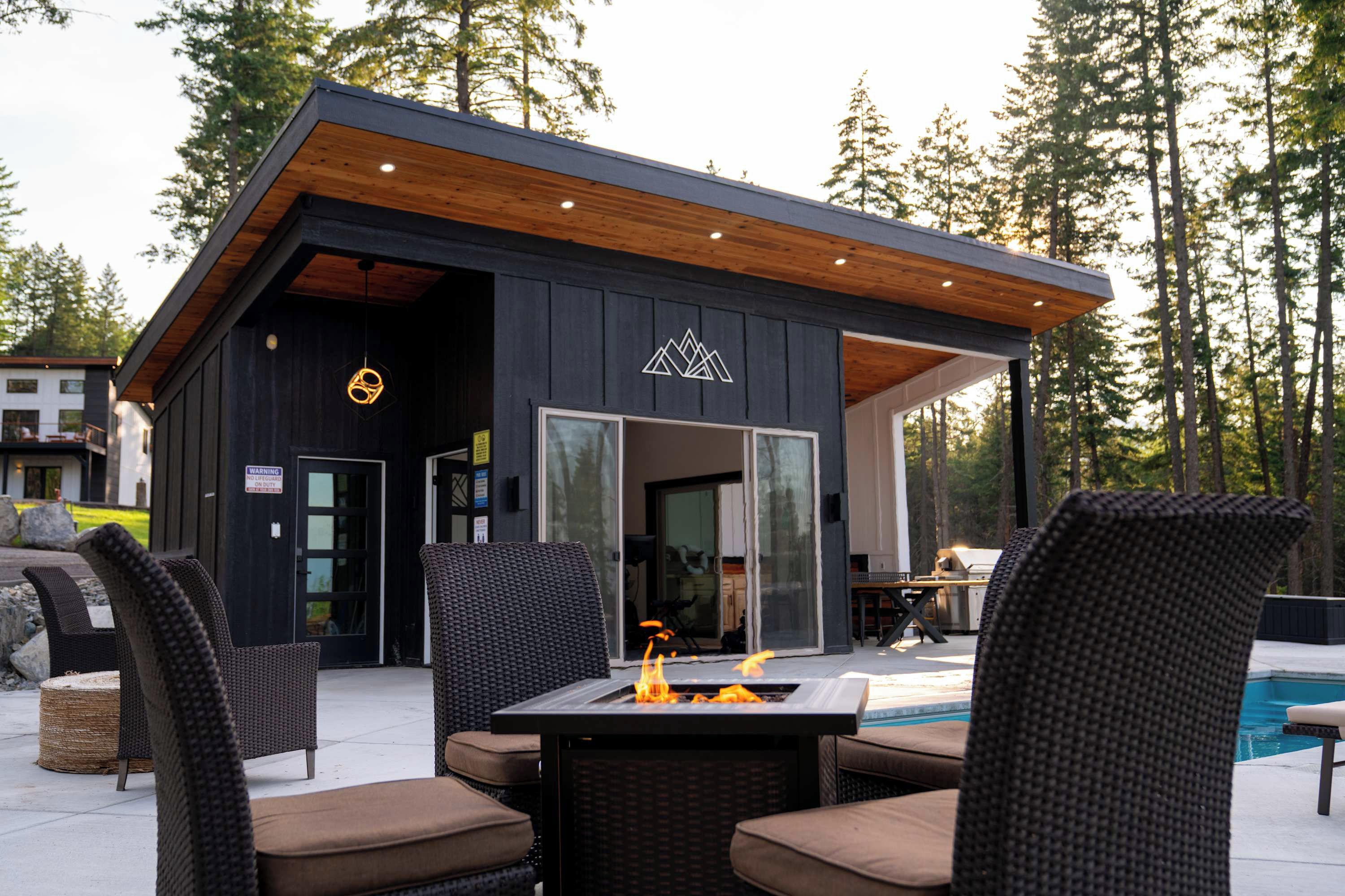 A modern outdoor seating area with wicker furniture and a fire feature.
