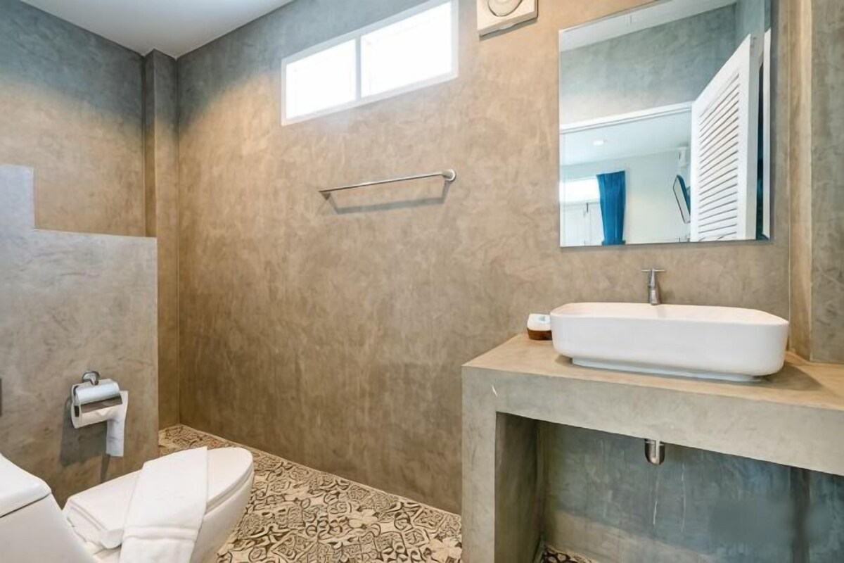 Een badkamer met een douche, toilet en wastafel.