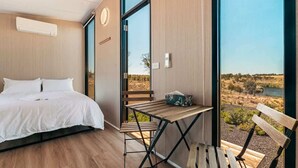 Un dormitorio con una cama grande, una mesa de madera y un banco.