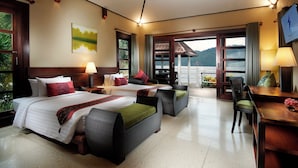 A hotel room with two beds, a dining table, a chair, and a TV. - Solitude Lembeh Resort (Bitung)