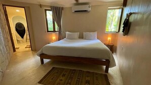 Ein Schlafzimmer mit einem großen Bett, zwei Nachttischlampen und Holzboden.