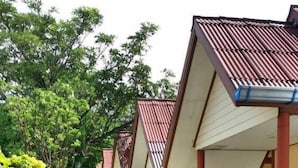 A row of hotel rooms with a tiled roof and a covered walkway. - Phi Phi Rimlay Resort (Phi Phi Islands)