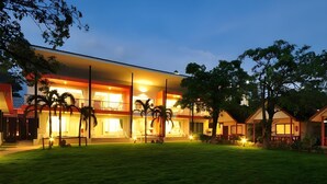 A modern hotel with a two-story structure, a well-maintained lawn, and palm trees. - Phi Phi Rimlay Resort (Phi Phi Islands)