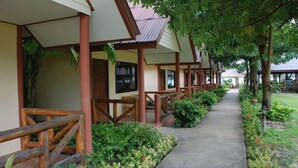 A row of wooden-framed buildings with a covered walkway and lush greenery. - Phi Phi Rimlay Resort (Phi Phi Islands)