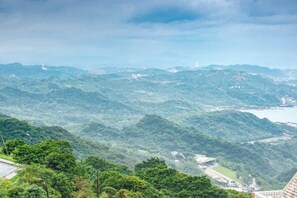 A panoramic view of a mountainous landscape with a building in the foreground. - Kite Museum (New Taipei City)