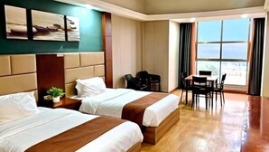 A hotel room with two beds, a dining table, chairs, and a view of the sea. - Pai Hotel (Chenzhou Yizhang County Yiren Plaza Branch) (Yizhang)