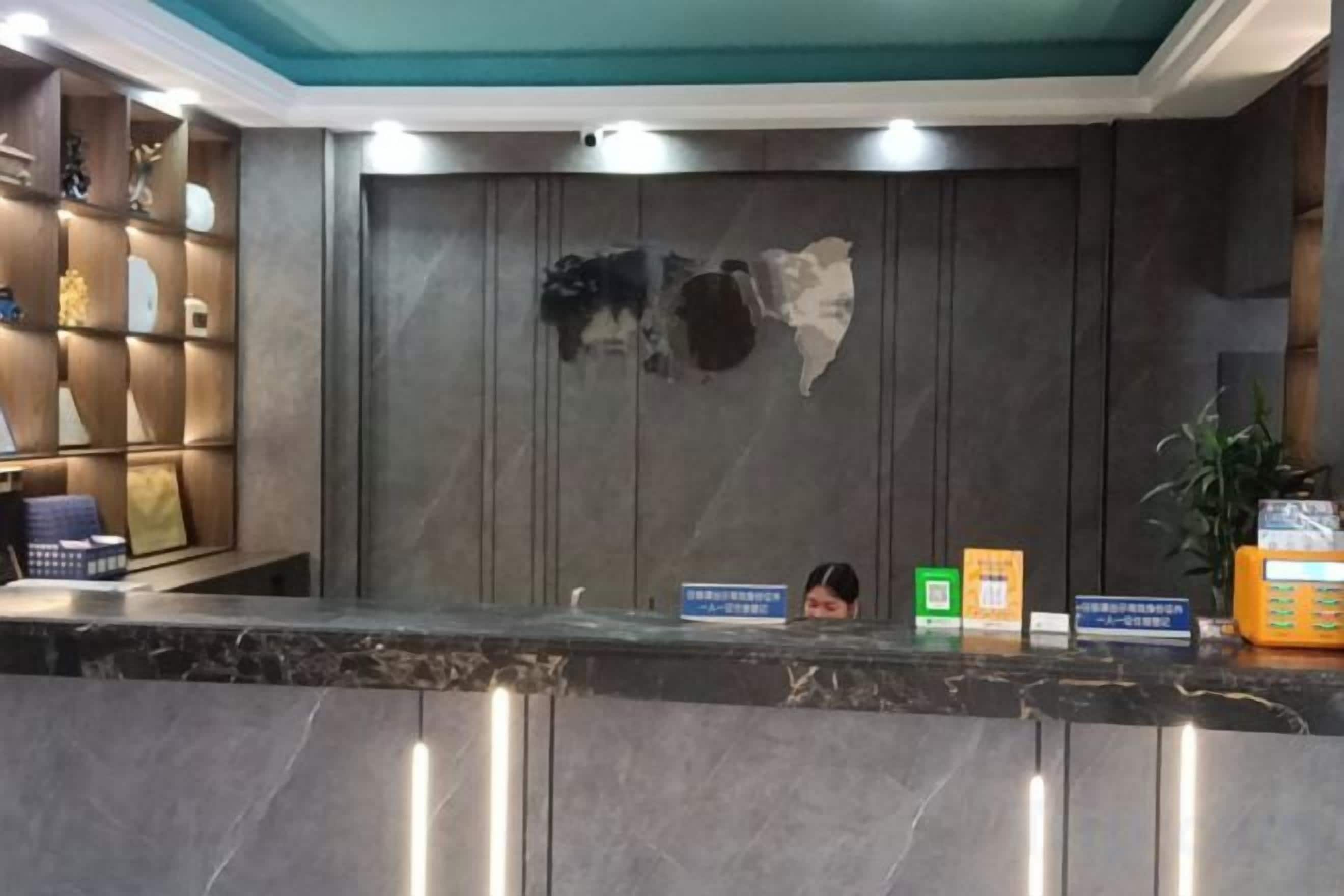 A reception desk with a marble top, a wall-mounted map, and a shelf with various items.