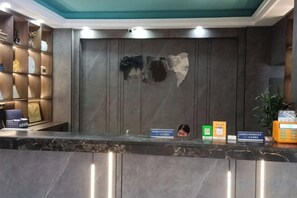 A reception desk with a marble top, a wall-mounted map, and a shelf with various items. - Pai Hotel (Chenzhou Yizhang County Yiren Plaza Branch) (Yizhang)