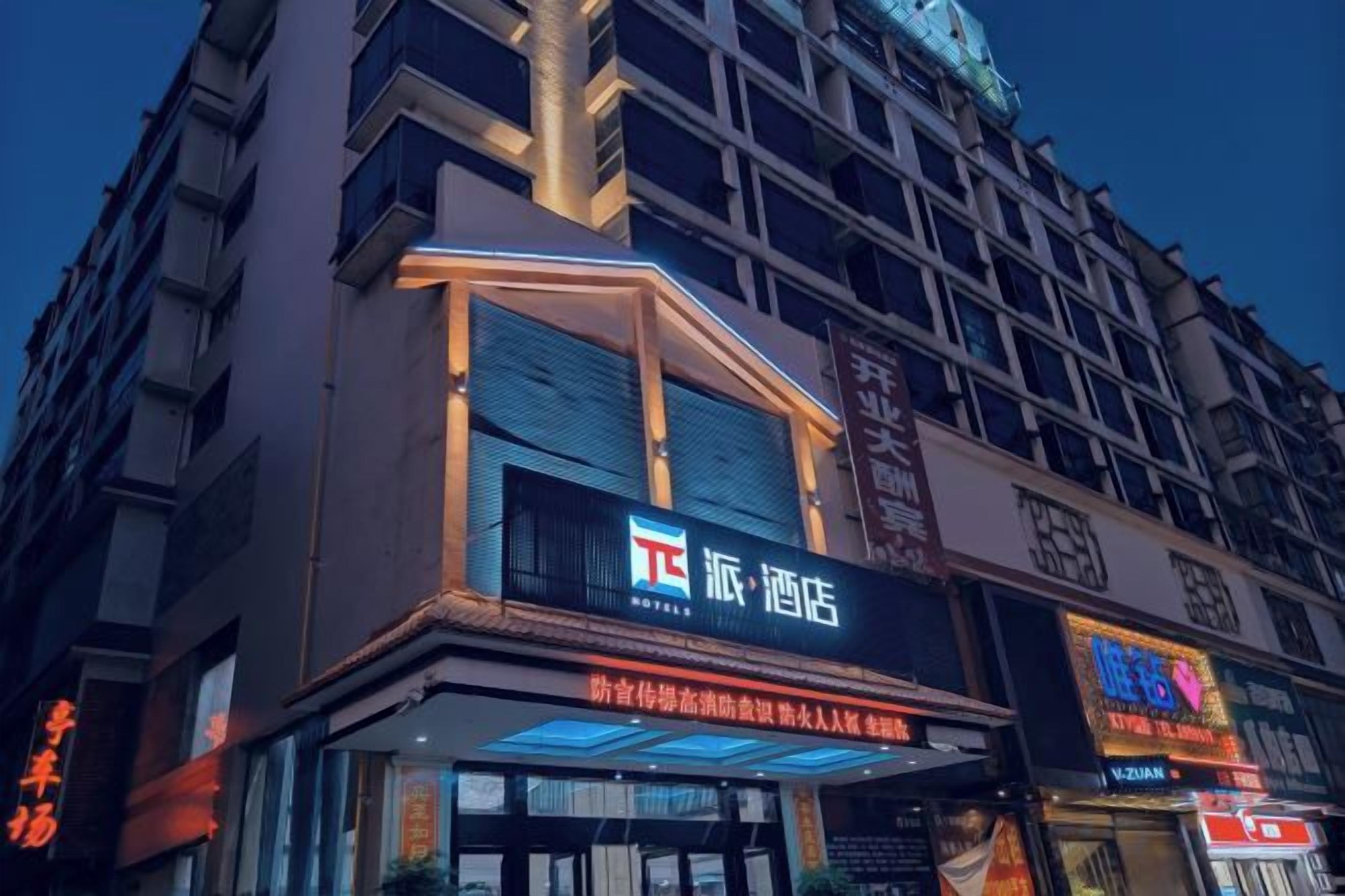 A hotel with a prominent sign, multiple floors, and a modern facade.