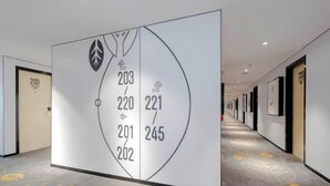 A hallway with a large directional sign indicating room numbers 201, 202, 203, 220, 221, and 245. - Changee Hotel MINI (Shanghai Jinshan City Beach) (Shanghai)