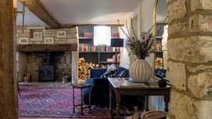 A cozy room with a fireplace, a bookshelf, and a large mirror. - The Mill House Beautiful 4BD Family Home (Stroud)