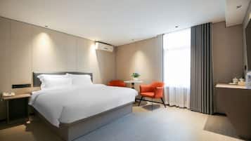 Quarto de hotel moderno com uma cama grande, uma escrivaninha e uma cadeira.