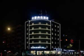 A multi-story hotel with illuminated signage, a flat facade, and a series of windows on each floor. - Zhonghao Shangpin Hotel (Wenzhou Zhuangyuan Branch) (Wenzhou)