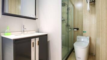 Une salle de bain moderne avec un lavabo, un miroir et des toilettes, le tout de couleur blanche.