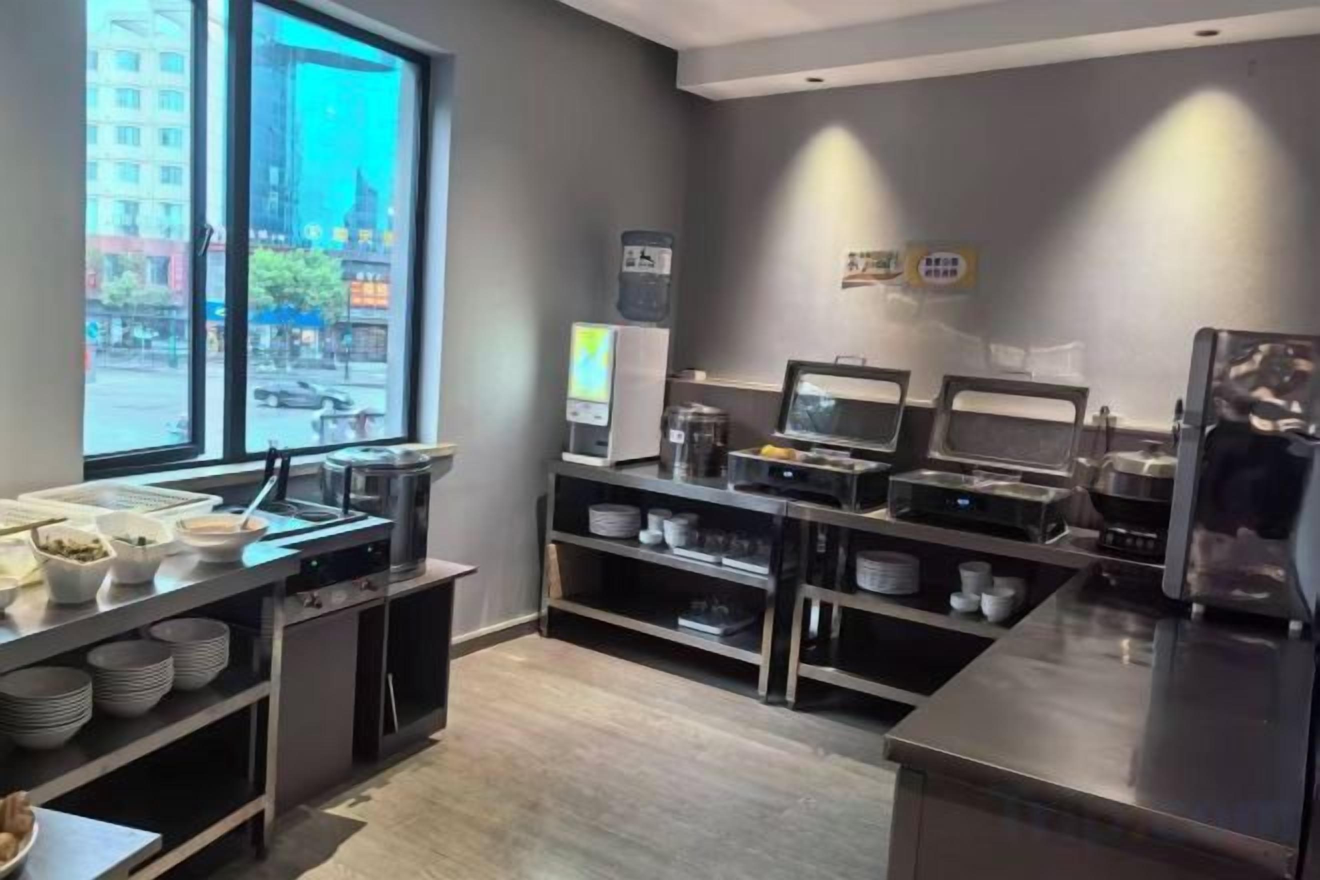 Una cocina moderna con una barra de estilo buffet, que incluye un refrigerador, microondas y diversos alimentos a la vista.