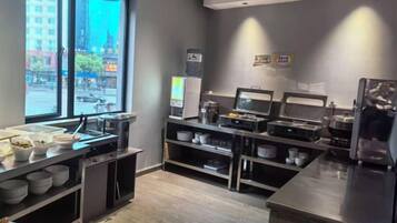Una cocina moderna con una barra de estilo buffet, que incluye un refrigerador, microondas y diversos alimentos a la vista.