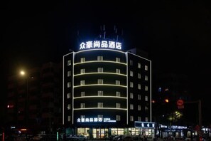 A multi-story hotel with illuminated signage and a modern architectural design. - Zhonghao Shangpin Hotel (Wenzhou Zhuangyuan Branch) (Wenzhou)