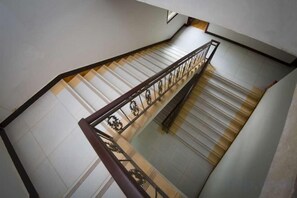 Un escalier avec une rampe en métal et un sol carrelé.