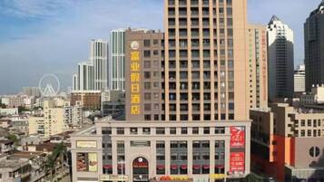 A hotel with a prominent sign, multiple floors, and a surrounding urban environment.