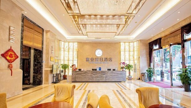 Un hall d’hôtel comprenant un comptoir d’accueil, un espace salon et de grandes fenêtres.