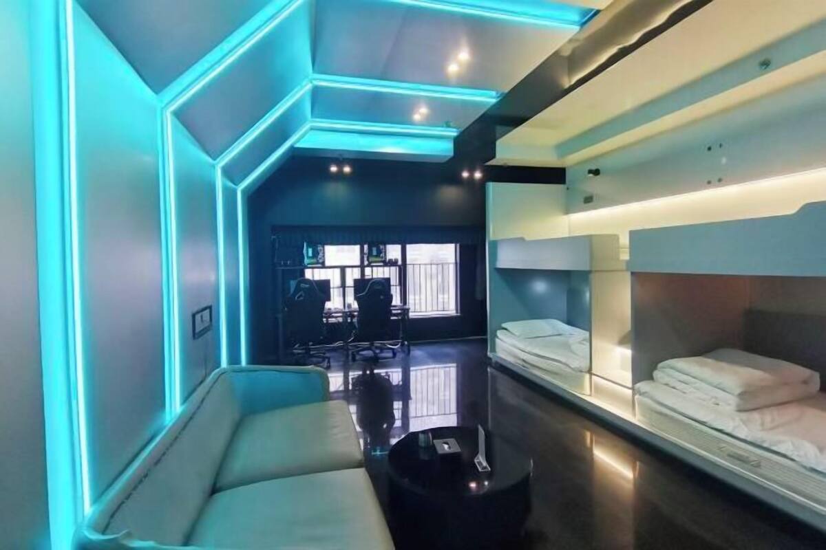 Een moderne hotelkamer met een bank, nachtkastje en een bed met keurig opgemaakt bedlinnen.