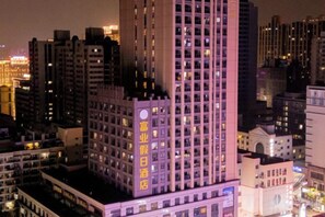 Un edificio de gran altura con varios pisos, que presenta una llamativa ventana circular en la fachada.