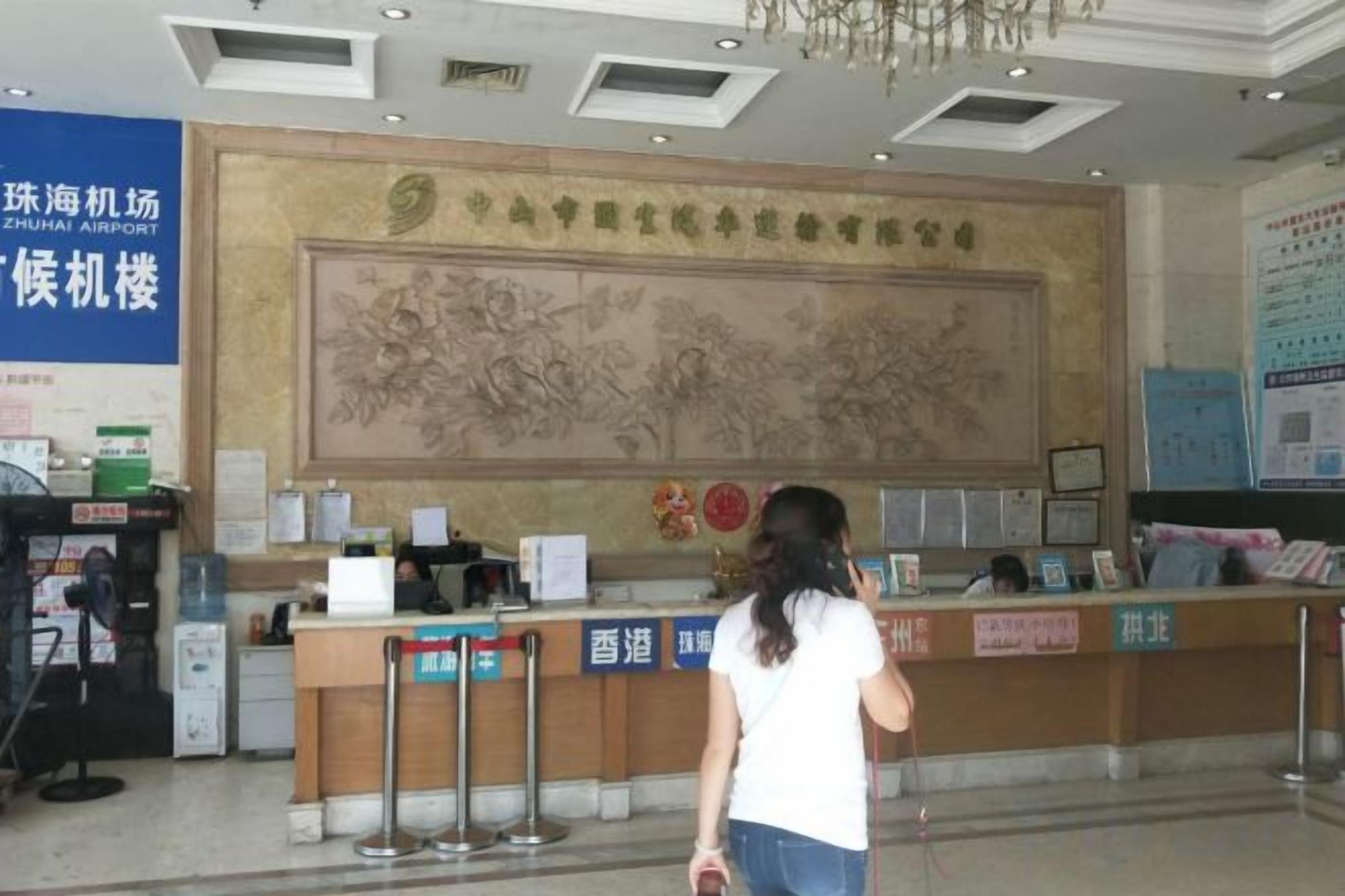A reception desk with a large wall mural, a blue sign, and a counter with a cash register.