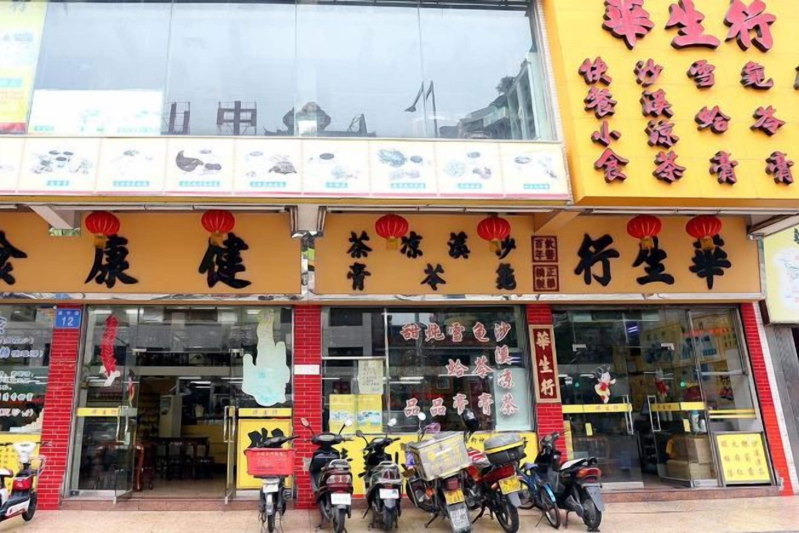 A storefront with Chinese signage, a glass entrance, and several motorcycles parked outside.